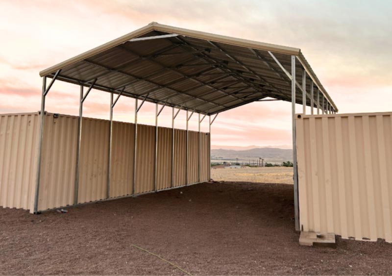Enclosed dark gray single pitch lean-to steel building garage featuring a secure white rolling shutter door on a concrete foundation pad.